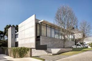 A modern architectural house featuring concrete and glass materials.