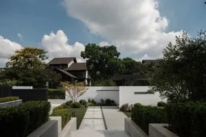 A modern residential exterior with a concrete pathway and landscaped garden.
