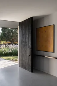 Modern industrial-style front door with a concrete base and wooden paneling in a residential entrance.