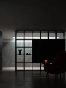 Modern lobby with marble floor and wall, featuring a red armchair.