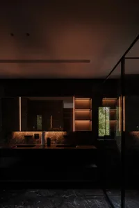 A modern bathroom with a marble countertop and illuminated cabinets.