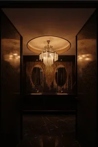 Interior of a modern bathroom featuring a luxurious chandelier and marble finishes.