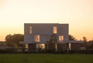 A modern residential home with a concrete exterior and large windows.