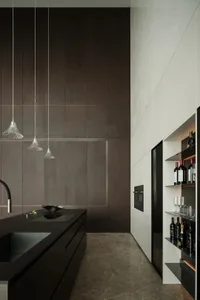 A modern, minimalist kitchen with marble countertops and white cabinets.