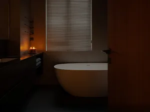 A modern bathroom featuring industrial elements with a focus on minimalist design and industrial touches, including a freesta