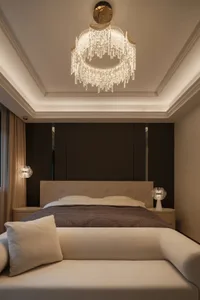 A modern bedroom featuring a bed with glass headboard and fabric bedding, illuminated by stylish pendant lights.