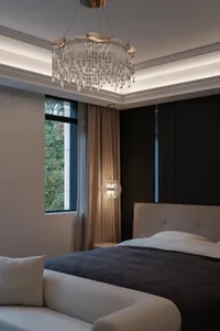Modern bedroom with a gray fabric bed, glass chandelier, and metal headboard.