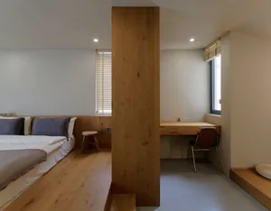 Modern bedroom with wooden flooring and minimalist design.