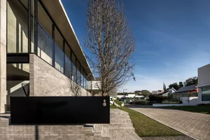 Modern building exterior with large glass windows and concrete structure.