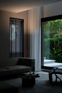 A modern interior design featuring neutral colors, glass walls, and wooden furniture.