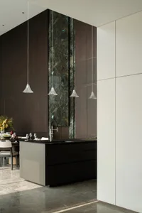Modern kitchen interior featuring marble countertops, wooden cabinets, and stainless steel appliances