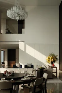Modern living room with neutral tones, featuring a chandelier, sofas, and dining table with chairs.