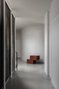 Modern minimalist interior space with concrete surfaces and steel elements.