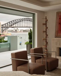 Contemporary living room with modern furniture, a cactus plant, and a view of the Sydney Opera House and Harbour Bridge acros