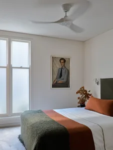 Minimalist bedroom featuring textiles and a potted plant