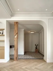A minimalist entry hall featuring marble floors, wooden accents, and terrazzo patterns.