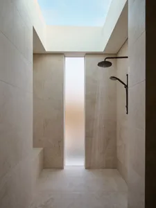 Modern bathroom with a skylight and tiled walls.