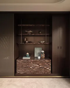 A modern dark wood furniture display with shelves and drawers containing various ceramic objects and books.