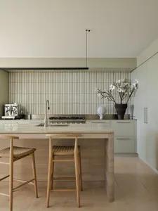 Modern kitchen featuring metallic tiles, wooden cabinets, and a marble countertop.
