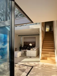 A modern living area featuring wood, glass, and concrete materials.