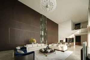 A modern living room with a large wooden wall and a crystal chandelier hanging from the ceiling.