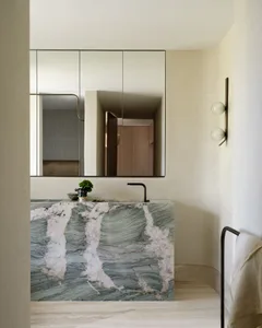 A modern marble bathroom featuring sleek lines, a black faucet, and minimalist design.