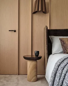 Minimalistic bedroom showcasing wooden furniture and light-colored bedding.