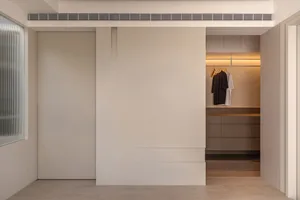 A modern minimalist wardrobe cabinet with sleek design and integrated lighting features.