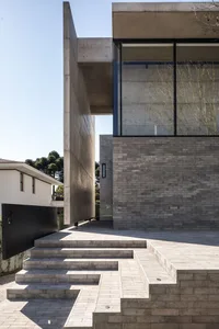A modern residential building with concrete walls and glass windows.