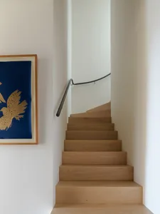 a modern staircase with wooden steps and a metal railing