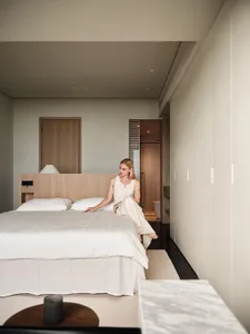 A minimalist bedroom with a soft, mixed material aesthetic.