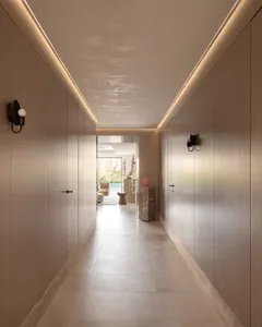 A modern interior of a corridor featuring concrete flooring and minimalist design elements.