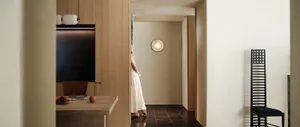 A sleek, modern entryway designed with wooden panels and stone flooring.