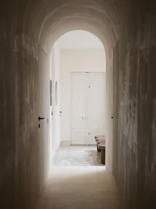 An image of a modern hallway featuring an architectural concrete archway.