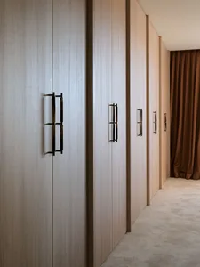 Modern, minimalist interior design featuring wooden cabinets and minimalist handles.