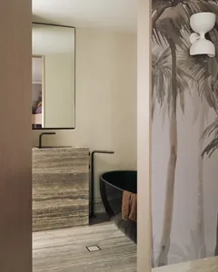 Modern bathroom with marble finishes and a palm tree mural.