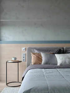 Modern minimalist bedroom with a gray headboard bed, wooden nightstand, and ceiling lighting