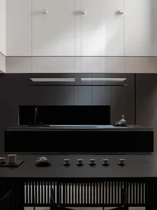 Modern minimalist kitchen with black stainless steel appliances and black countertops.