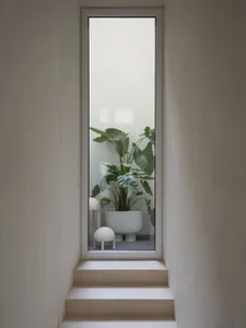 Modern staircase with indoor plant in a minimalist space.