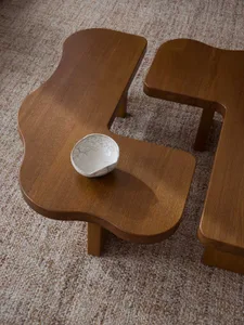 A modern, wooden, multi-segmented coffee table with a white ceramic bowl on one section.