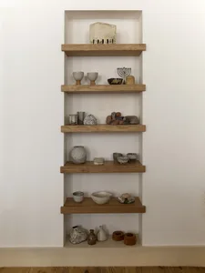 A collection of various ceramics and rocks displayed on wooden shelves.