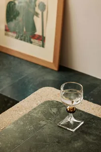 A minimalist home featuring a marble table setting with a glass of water.