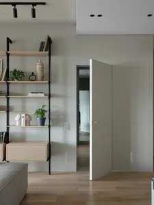 A minimalist, modern interior with open shelves, a floating drawer, and a partially open door.