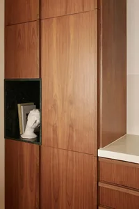 Modern wooden storage unit with a niche for books and a bust sculpture.
