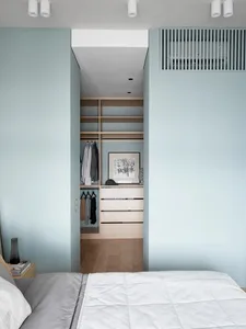 Modern minimalist bedroom featuring wood storage solutions.