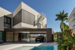 A modern residential building featuring concrete and glass materials.