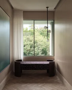 Modern living room with a comfortable window seat upholstered in wood-textured fabric, featuring a minimalist design and natu