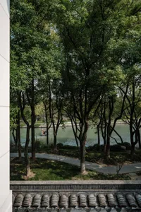 An urban park featuring a lake, greenery, and pathways.