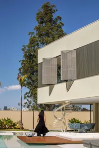A modern residential exterior with marble pool, concrete walls, and glass windows.