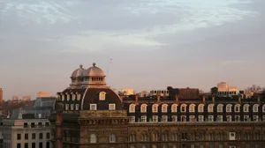 Sunlit evening cityscape featuring brick buildings with domes and spires.